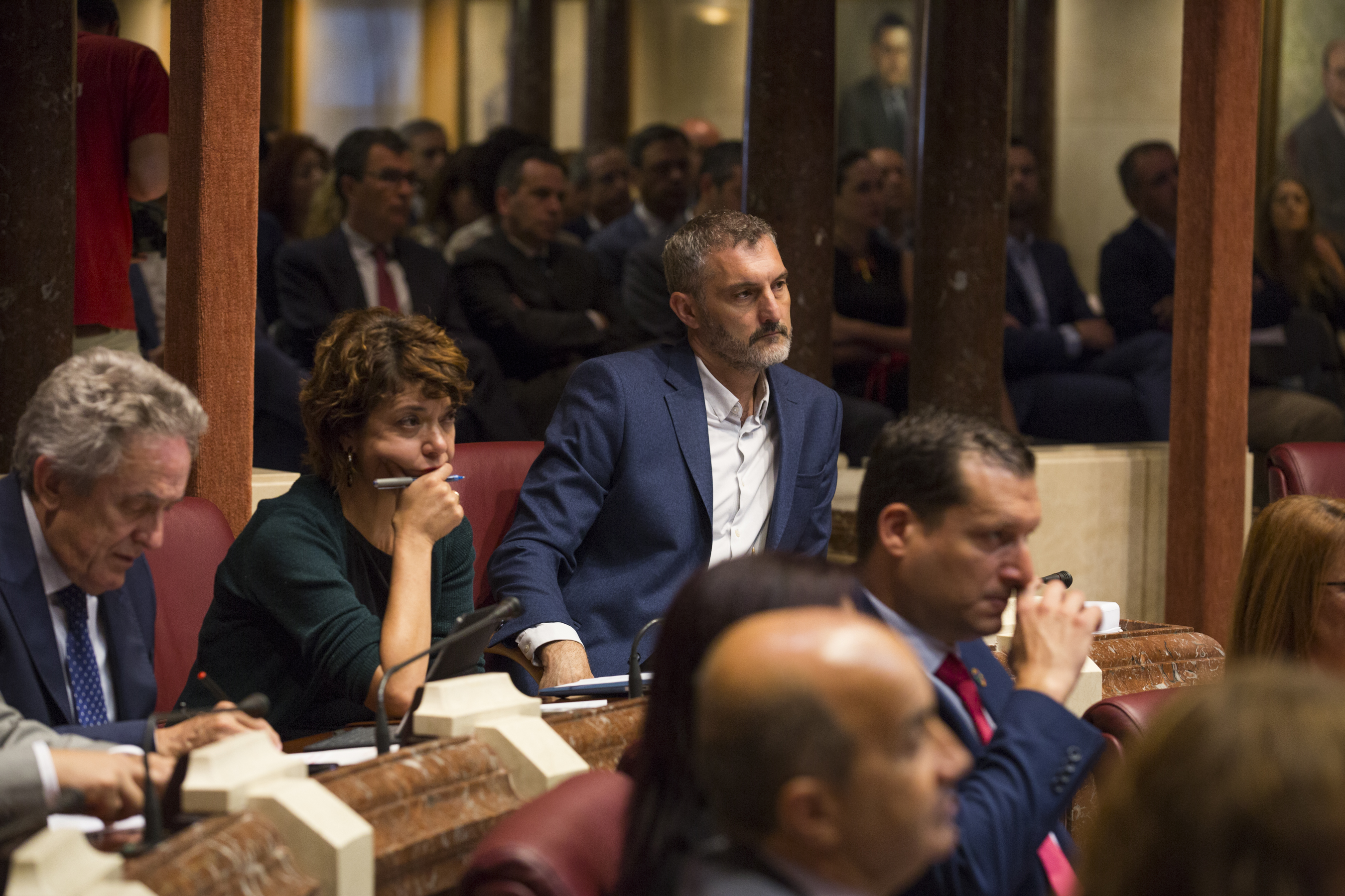 Los diputados de Podemos escuchan atentamente la intervención del candidato