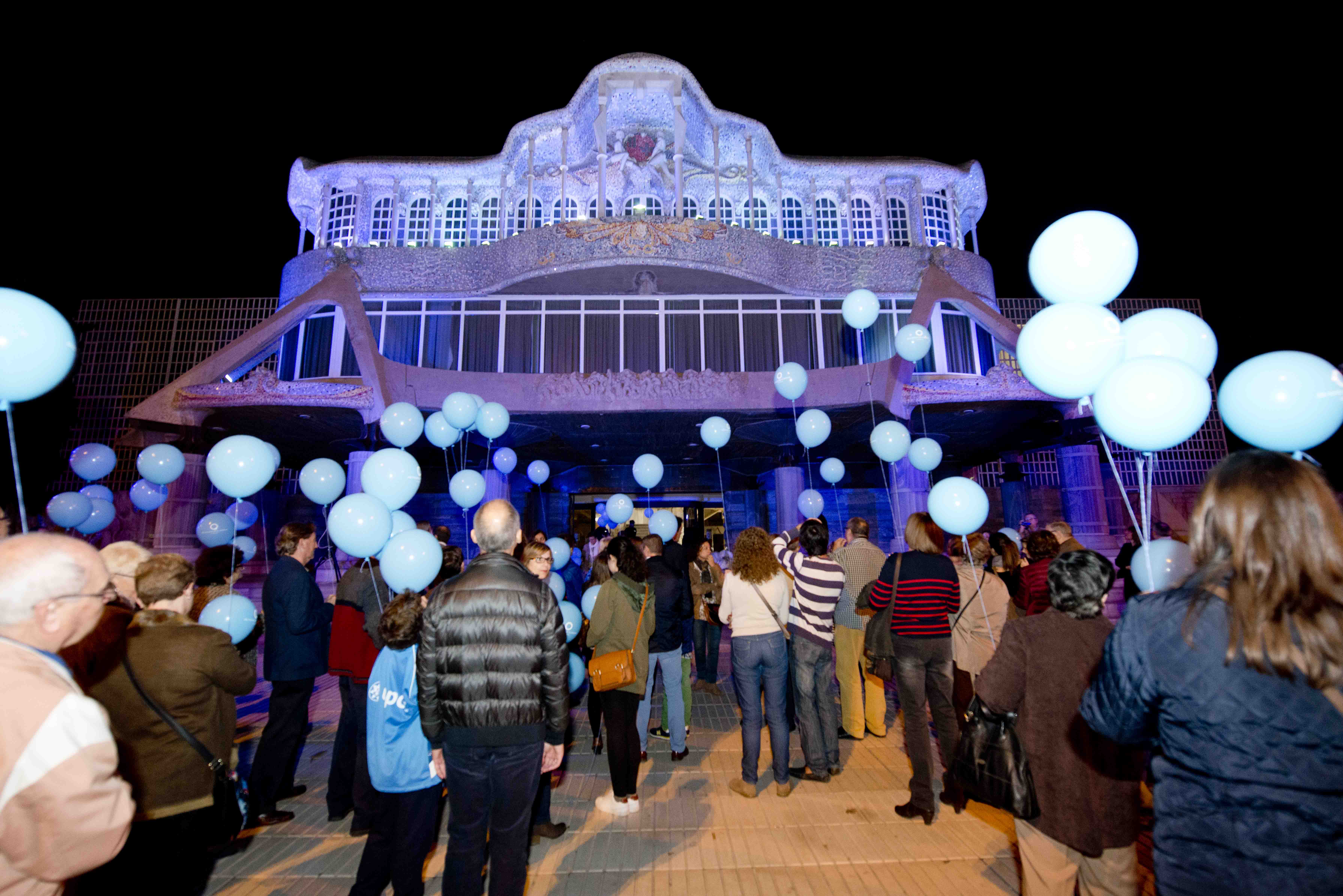 Suelta de globos y sentidos aplausos tras la iluminación de la fachada de la Asamblea de azul
