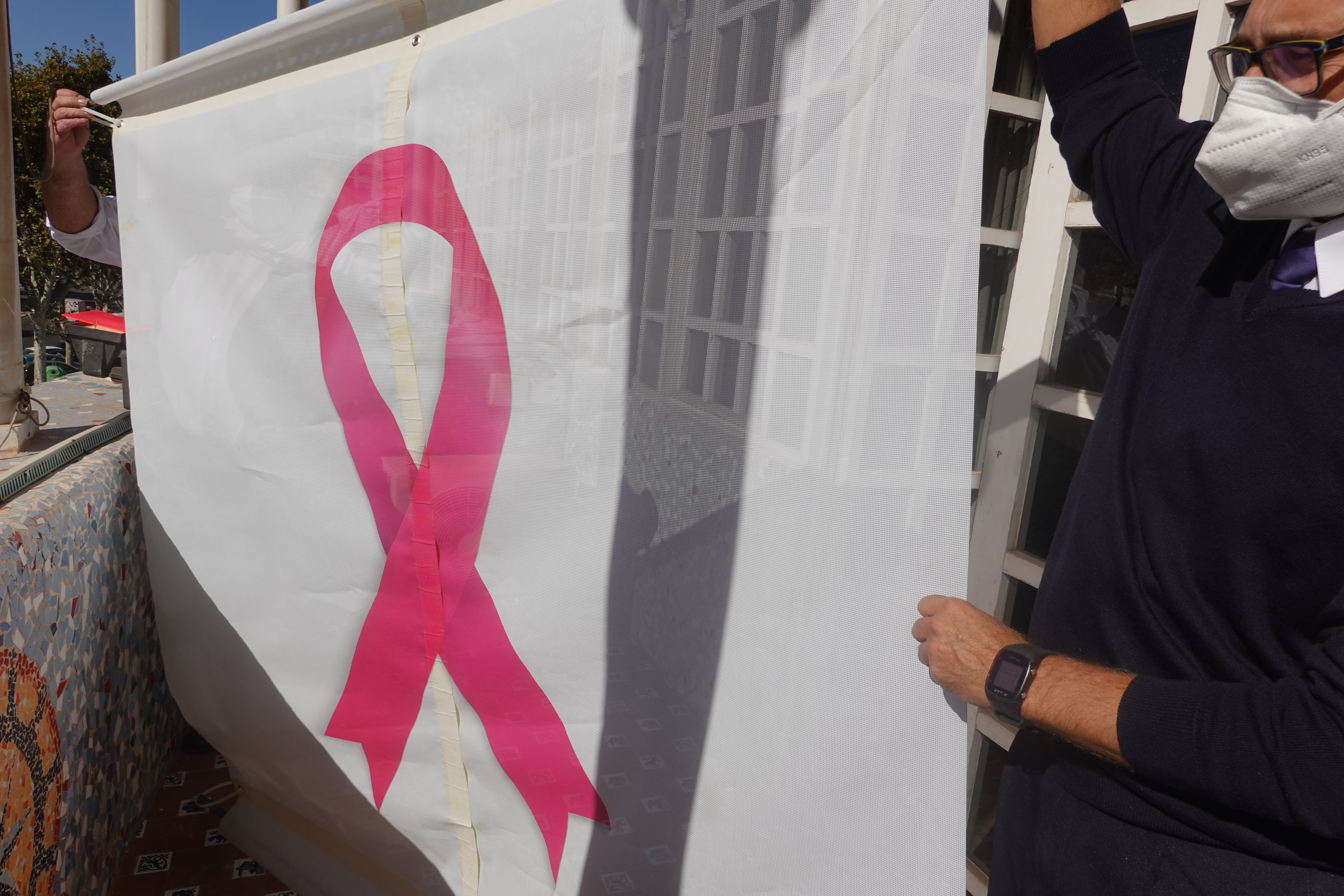 Funcionarios de la Asamblea colocan el lazo rosa en su fachada, para evidenciar el apoyo del Parlamento regional a las personas con cáncer de mama
