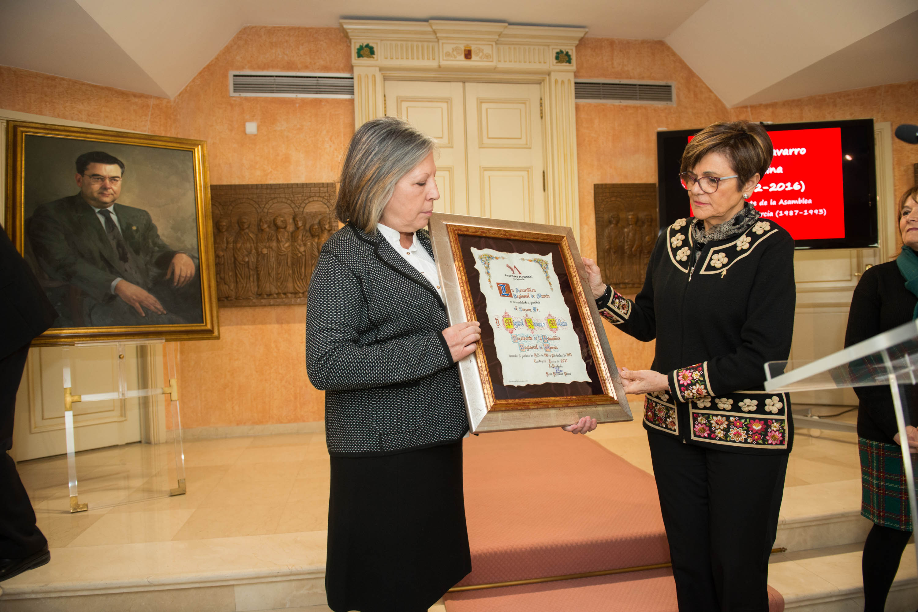 Rosa Peñalver entrega a la viuda de Miguel Navarro, Concepción Martínez, un pergamino en reconocimiento y gratitud a sus años como presidente del parlamento regional