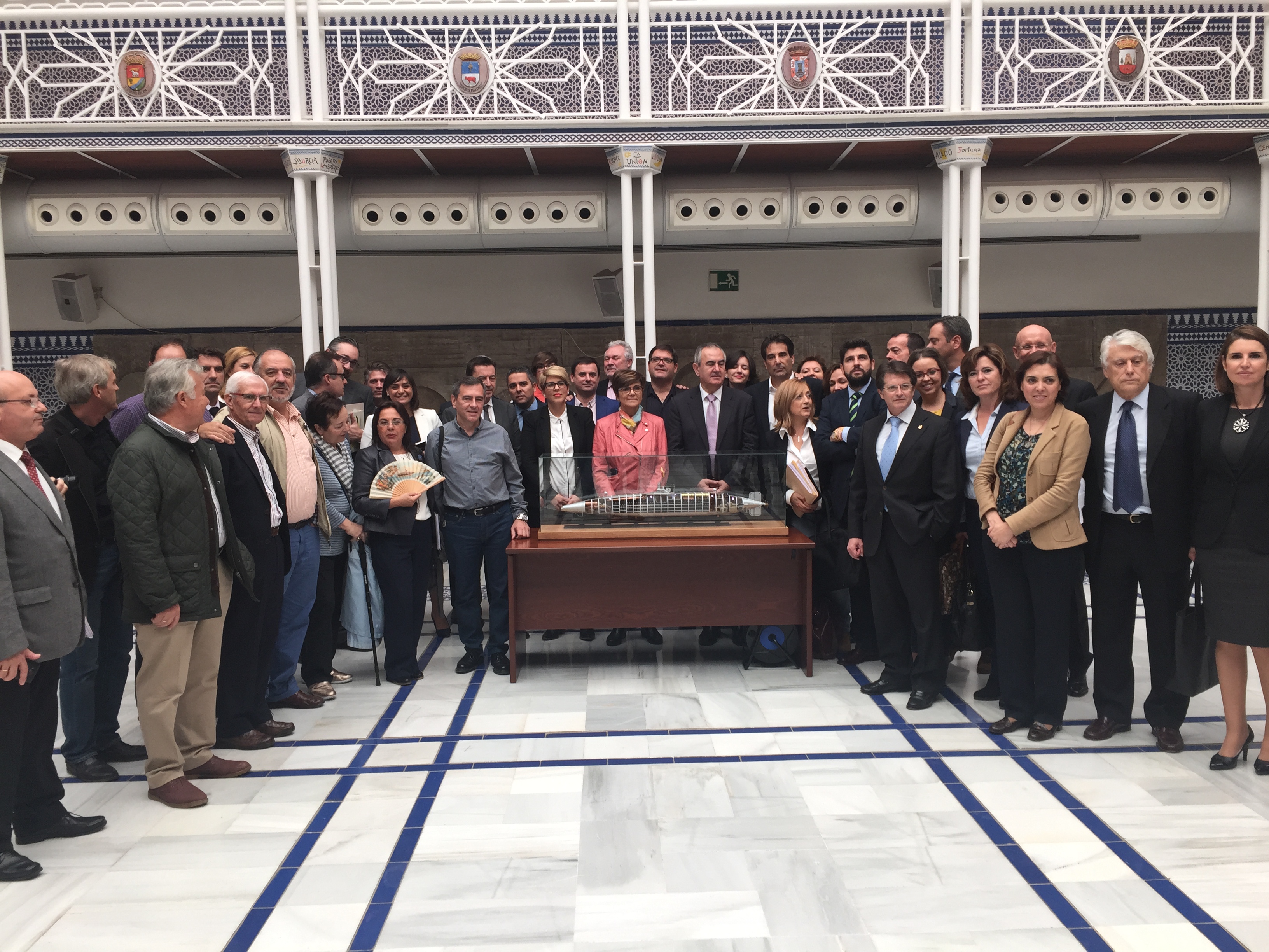 La presidenta de la Asamblea y la consejera de Cultura, posan con diputados de los cuatro Grupos Parlamentarios y el autor de la maqueta, Juan Ignacio Chacón