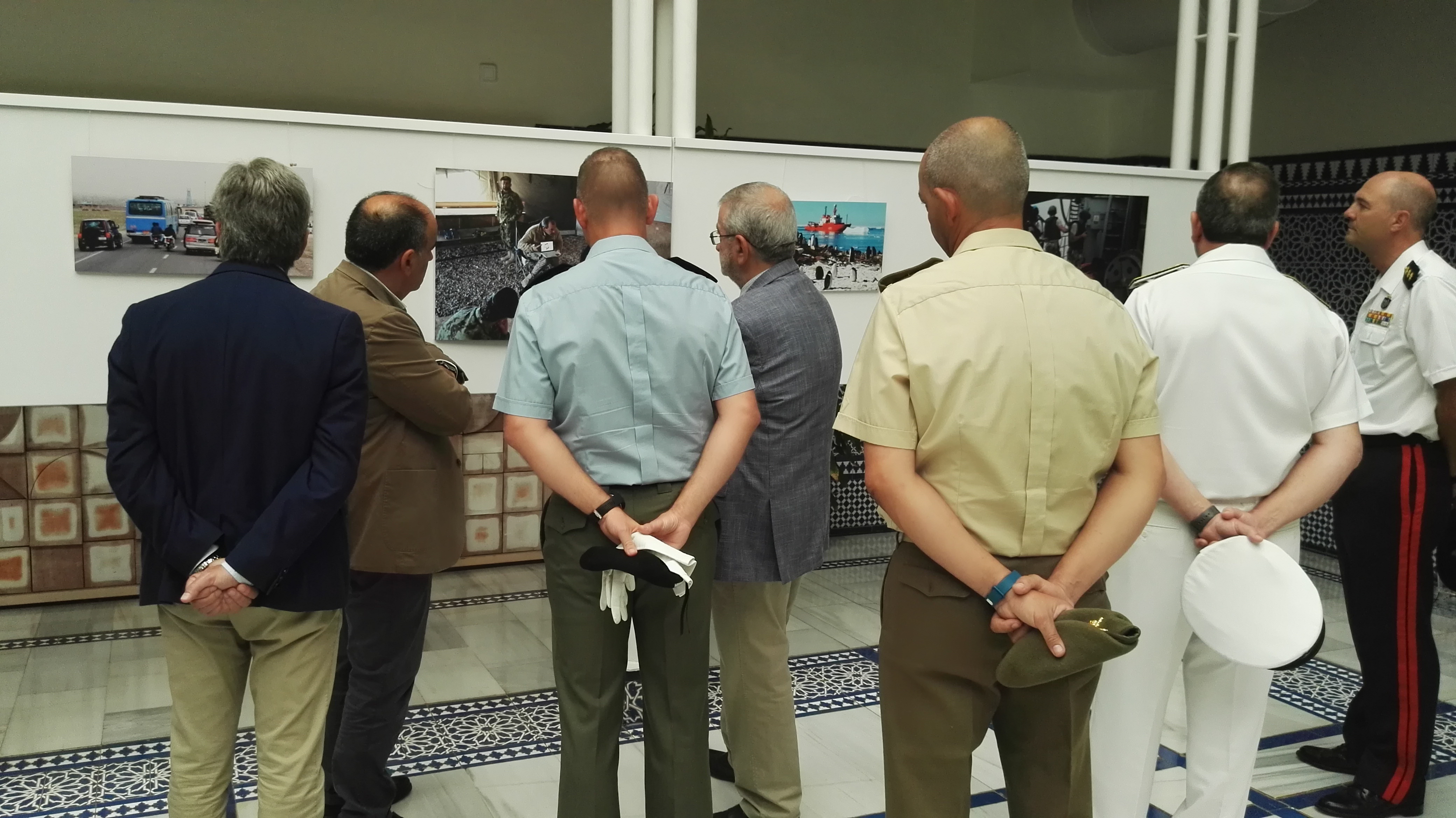 Militares de los tres Ejércitos observan las imágenes de la exposición junto a varios miembros de la Mesa de la Asamblea