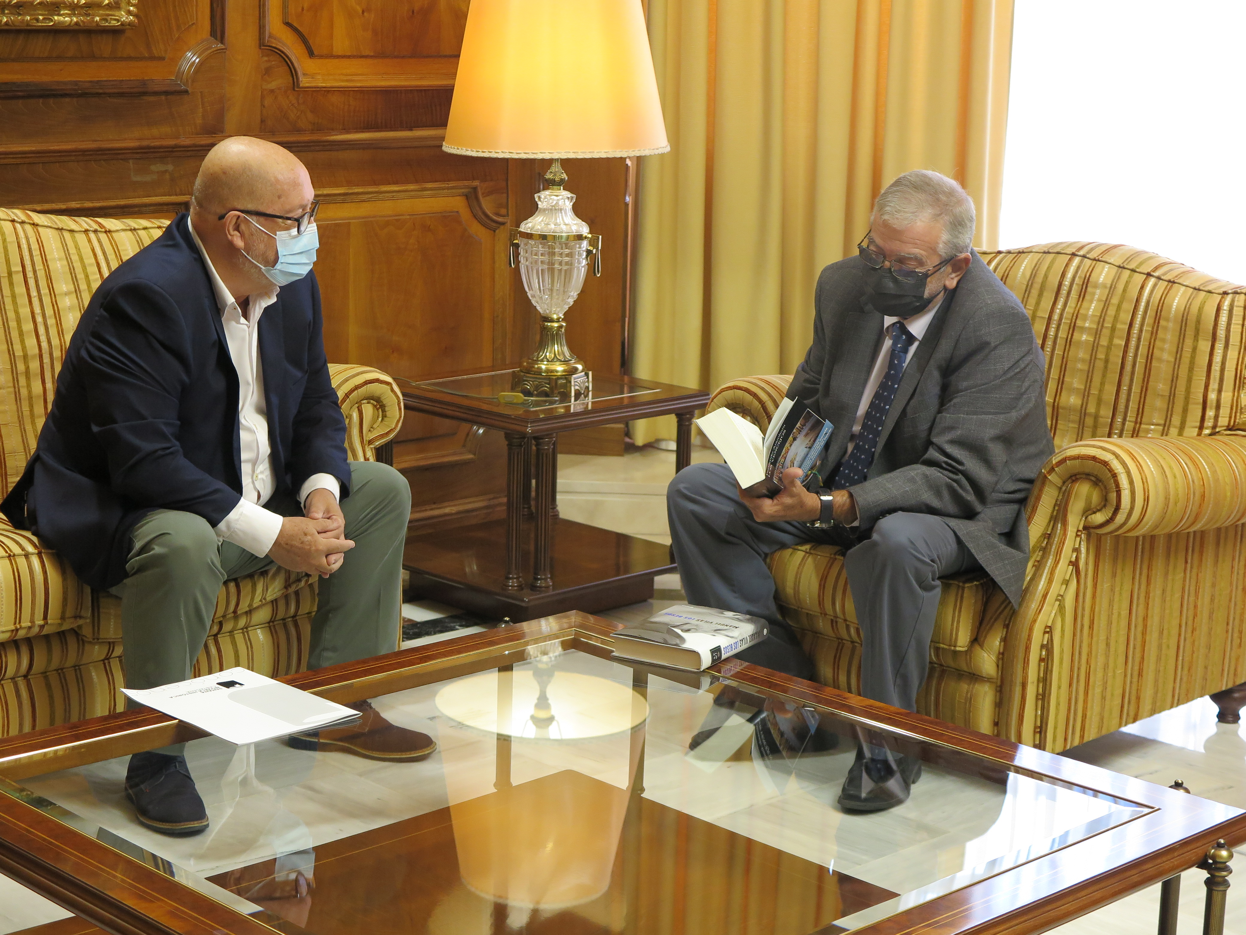 El presidente de la Asamblea Regional, Alberto Castillo, consulta un libro que le ha sido entregado por Obdulio López