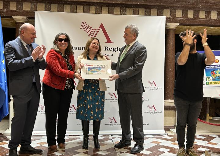 La presidenta de la Asamblea recibe de manos de la ONCE la lámina del cupón que se venderá el próximo 1 de marzo