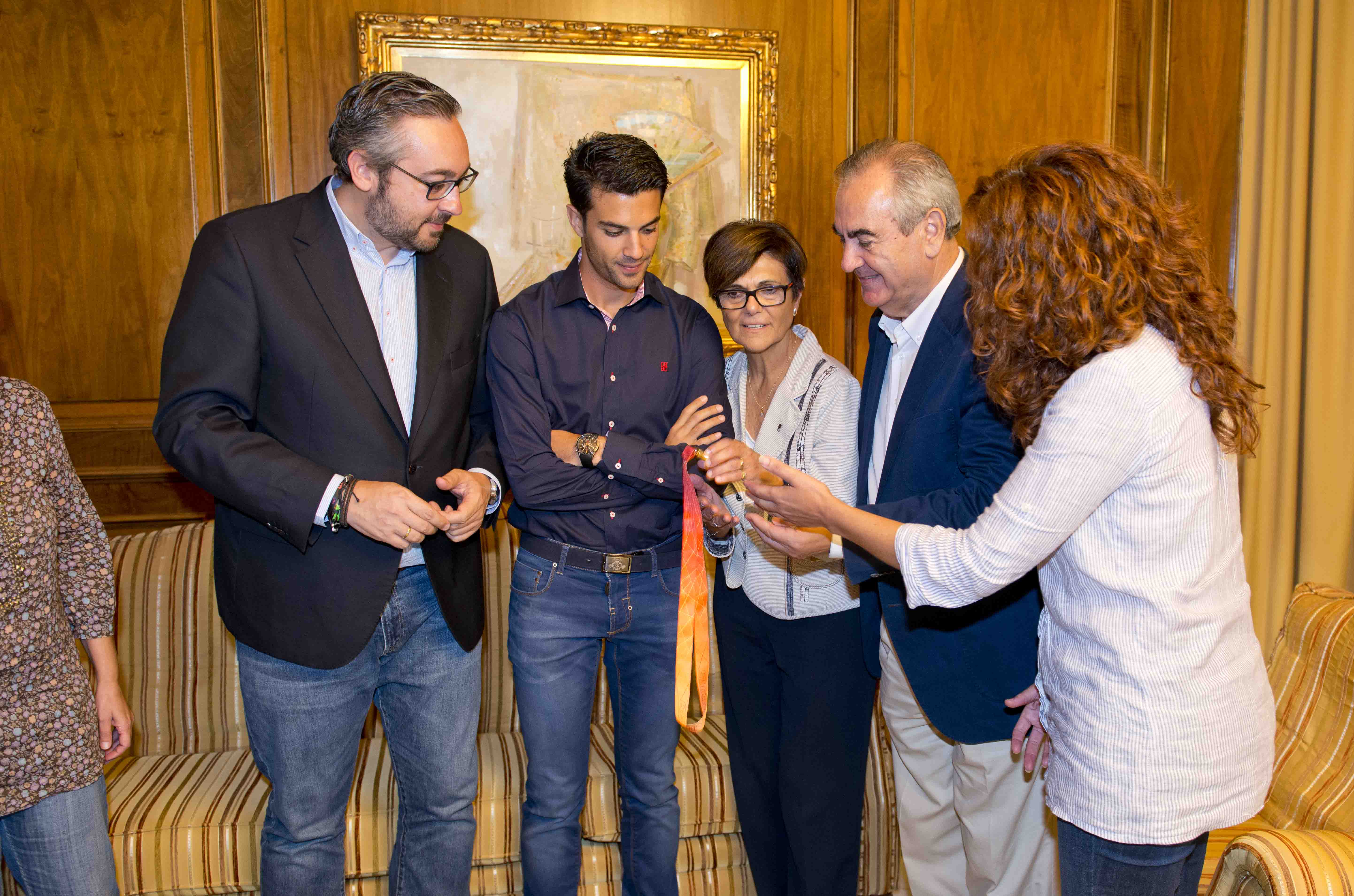Los diputados contemplan la medalla de oro ganada por Miguel Angel López en Pekín.