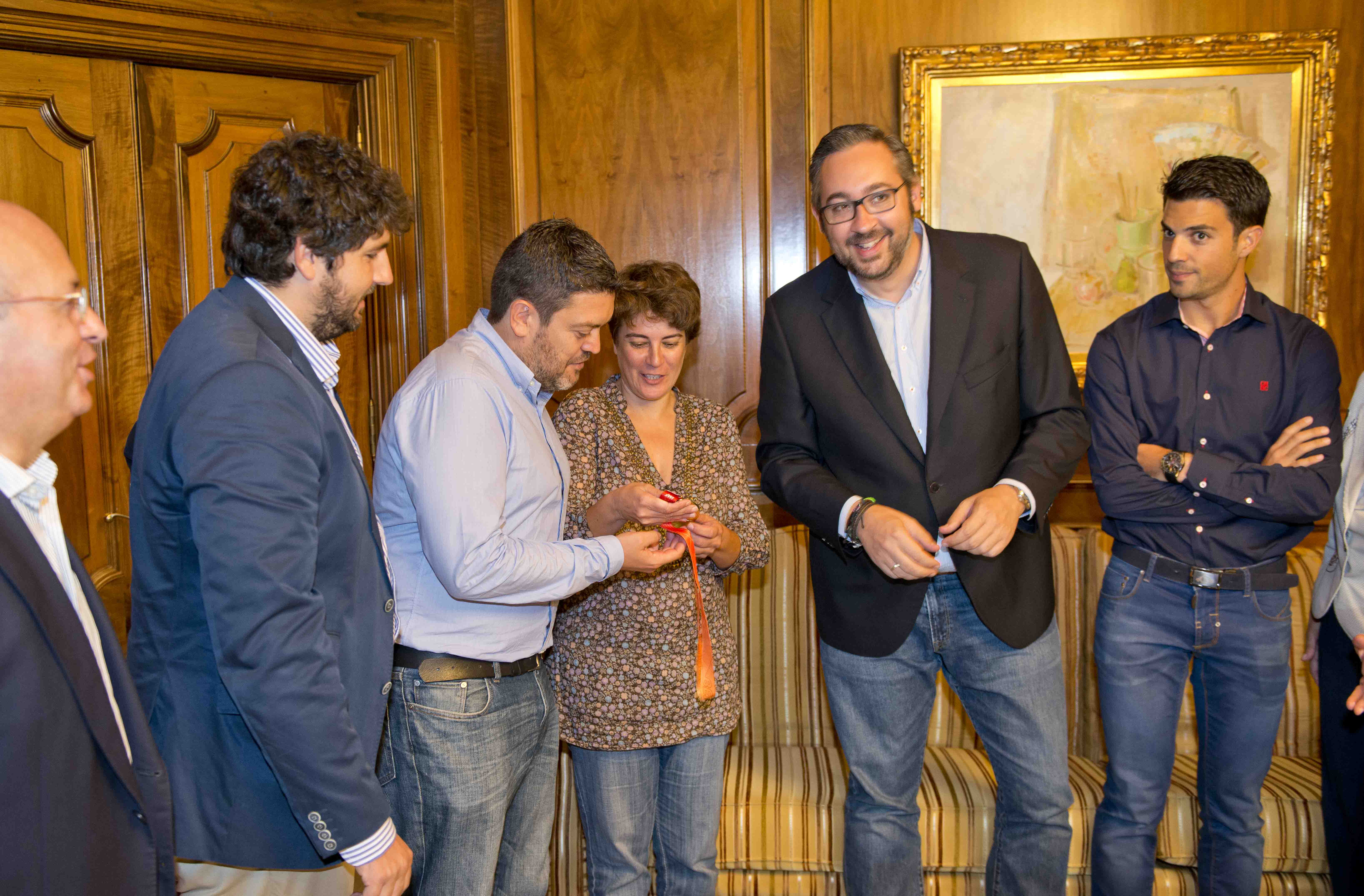 Varios diputados contemplan la medalla de oro ganada por Miguel Angel López en Pekín.